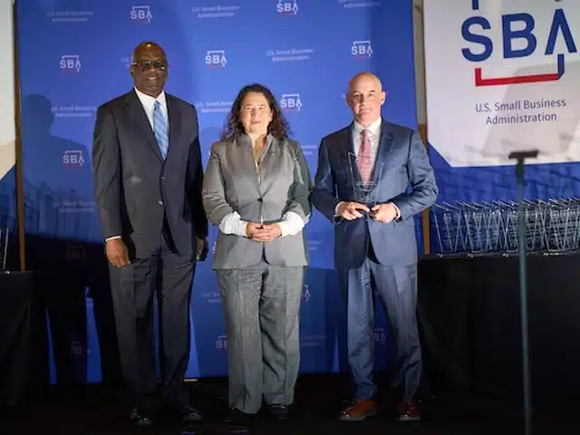Delta team receiving SBA award on stage.