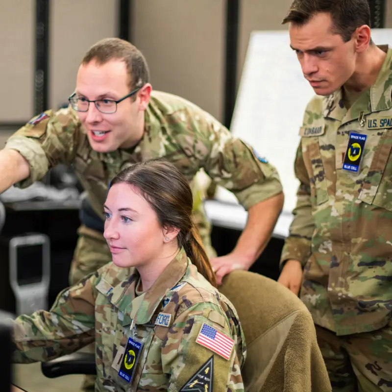 Military personnel collaborating during operations briefing.