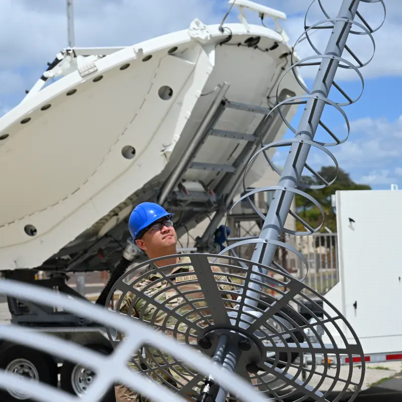 Service member working on satellite communications equipment.